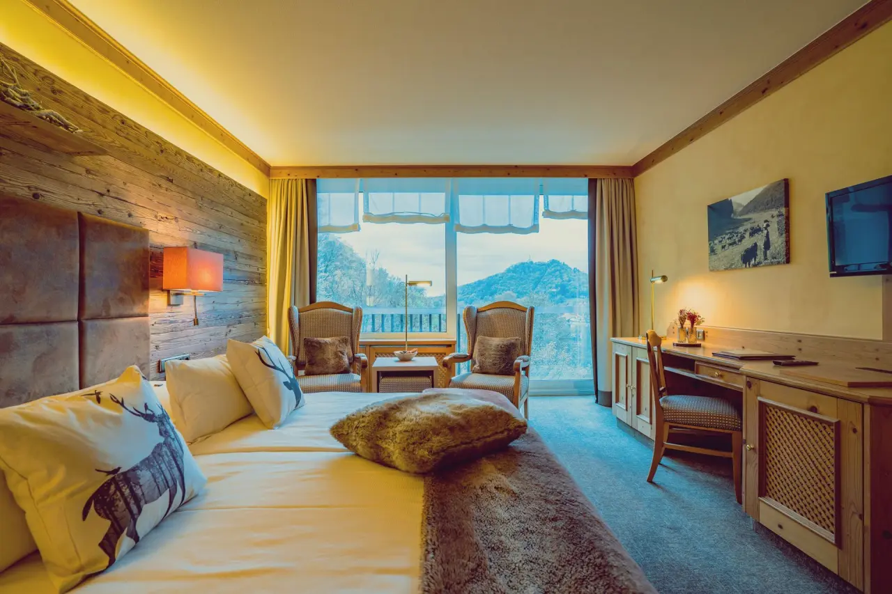 Gemütliches Hotelzimmer im Revita Wellnesshotel mit Doppelbett, Sitzbereich und Bergblick. Ideal für Entspannung.