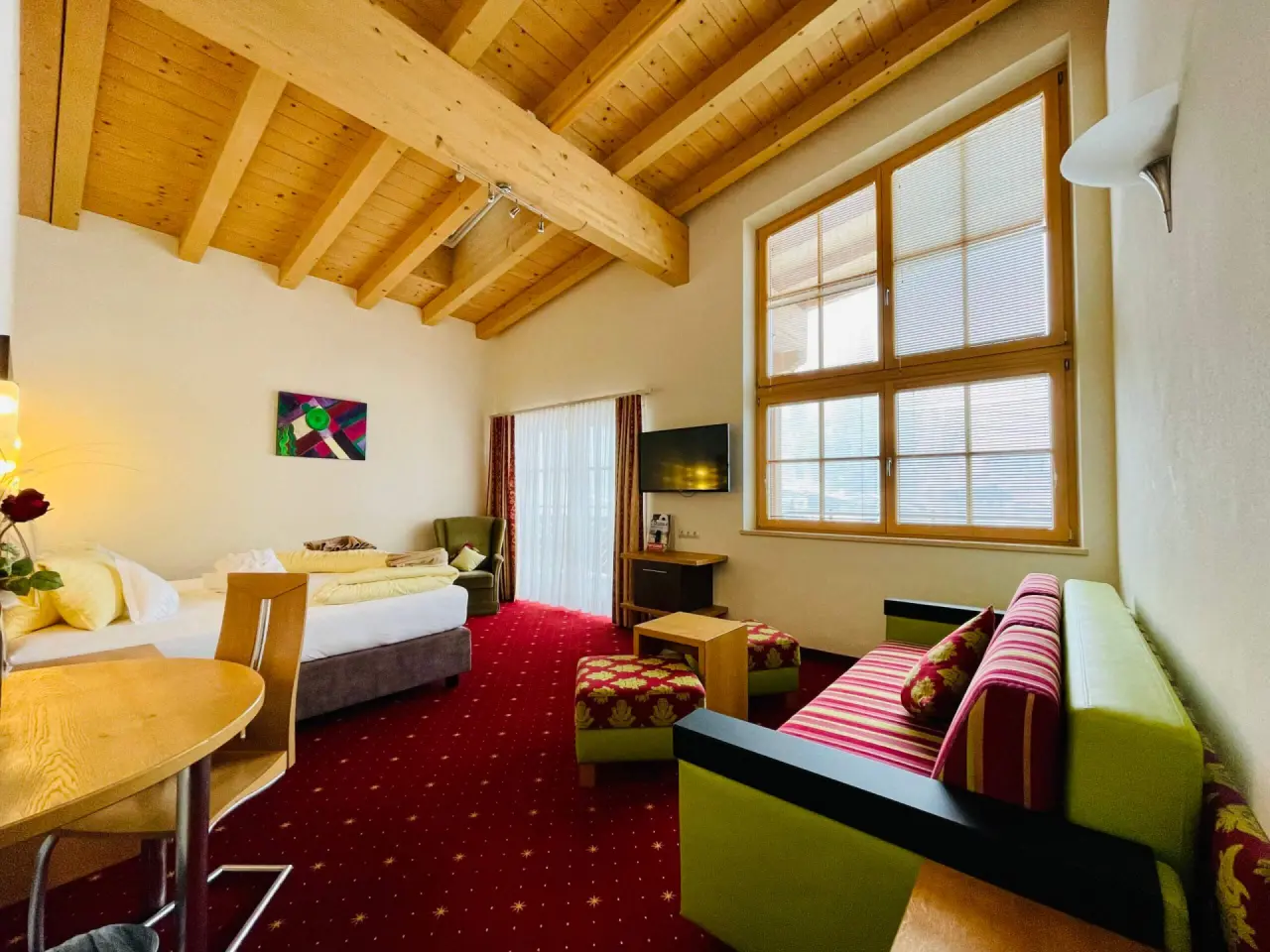 Gemütliches Doppelzimmer mit Holzbalkendecke und Sitzbereich im Wellness- & Familienhotel Egger.