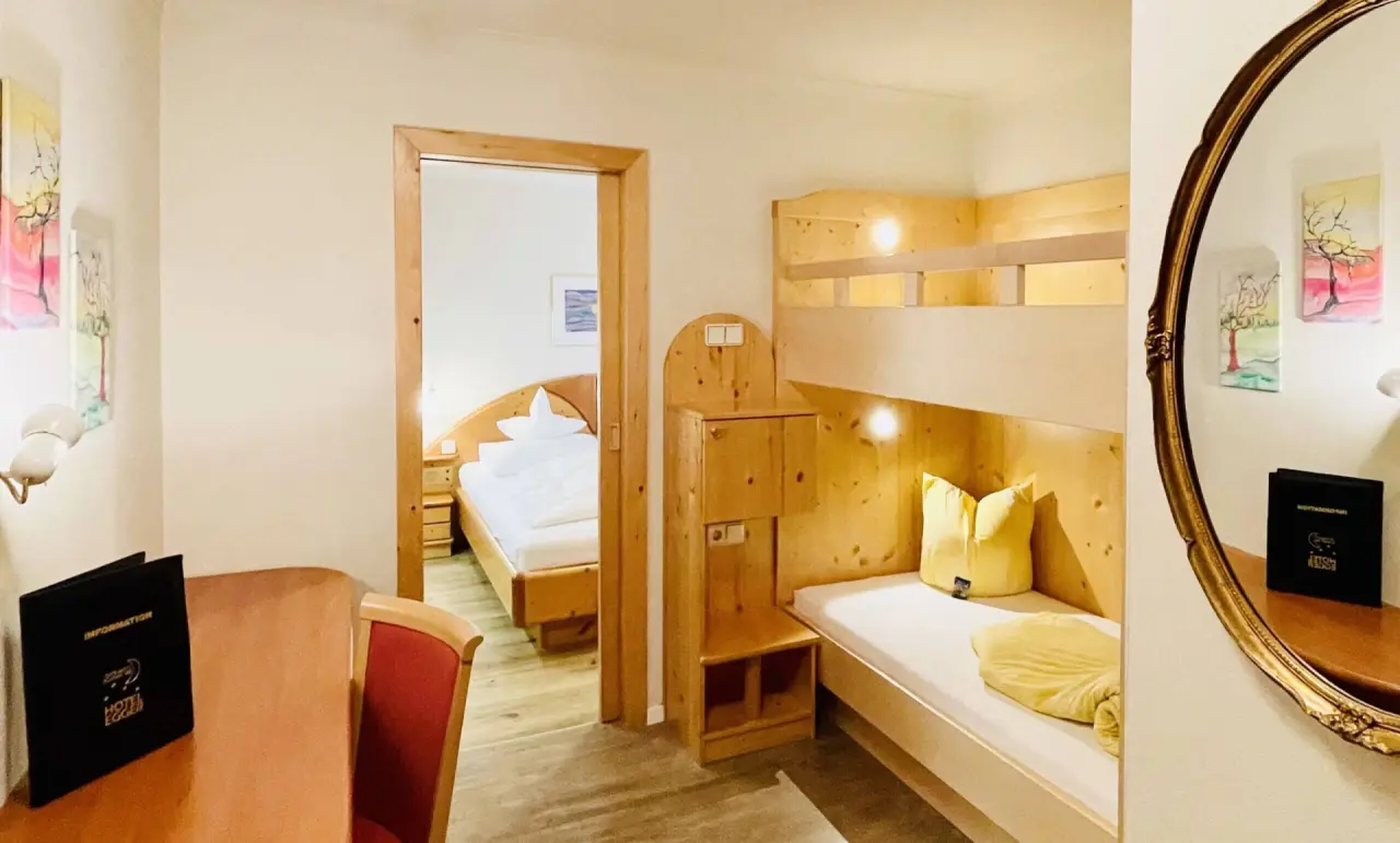 Familienzimmer mit Etagenbett und Blick auf Doppelbett im Wellness- & Familienhotel Egger.
