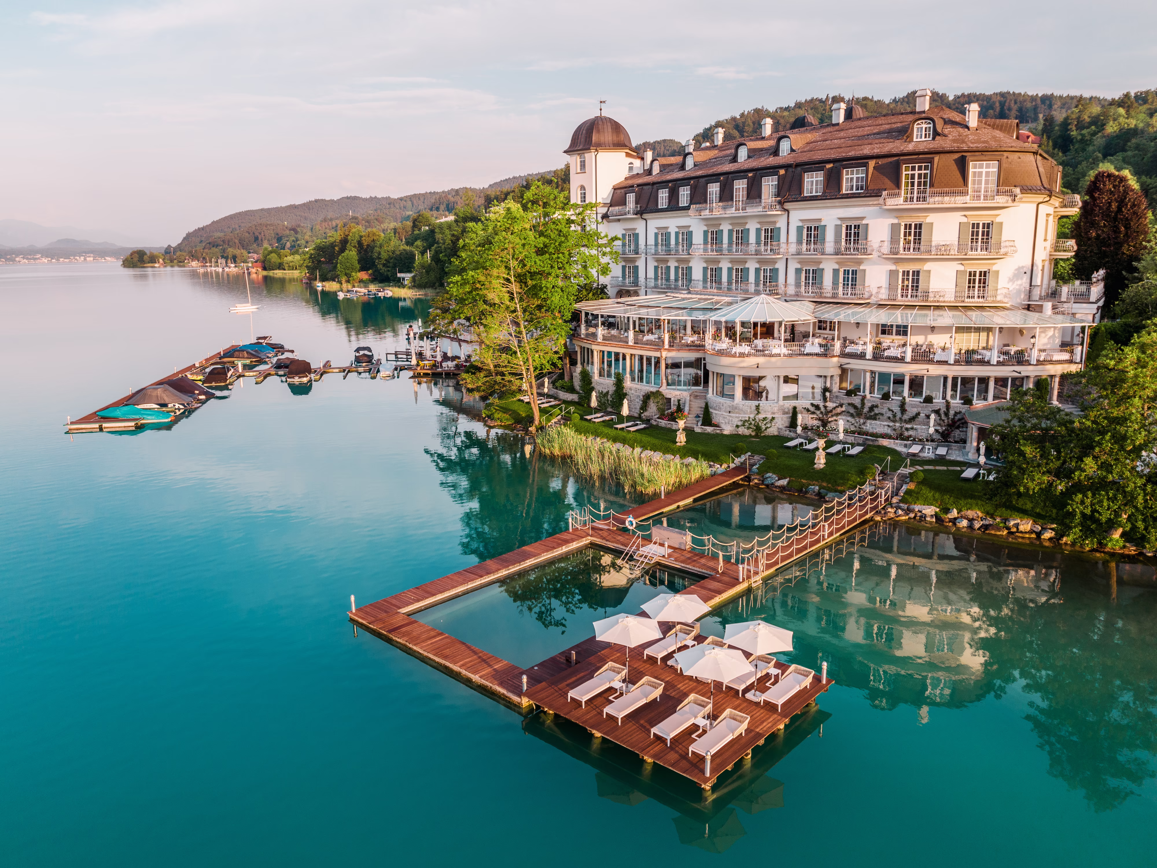 Hotel Schloss Seefels in Pörtschach – Luftaufnahme des Hotels mit Seezugang und schwimmendem Pool | Wellnesshotel Kärnten