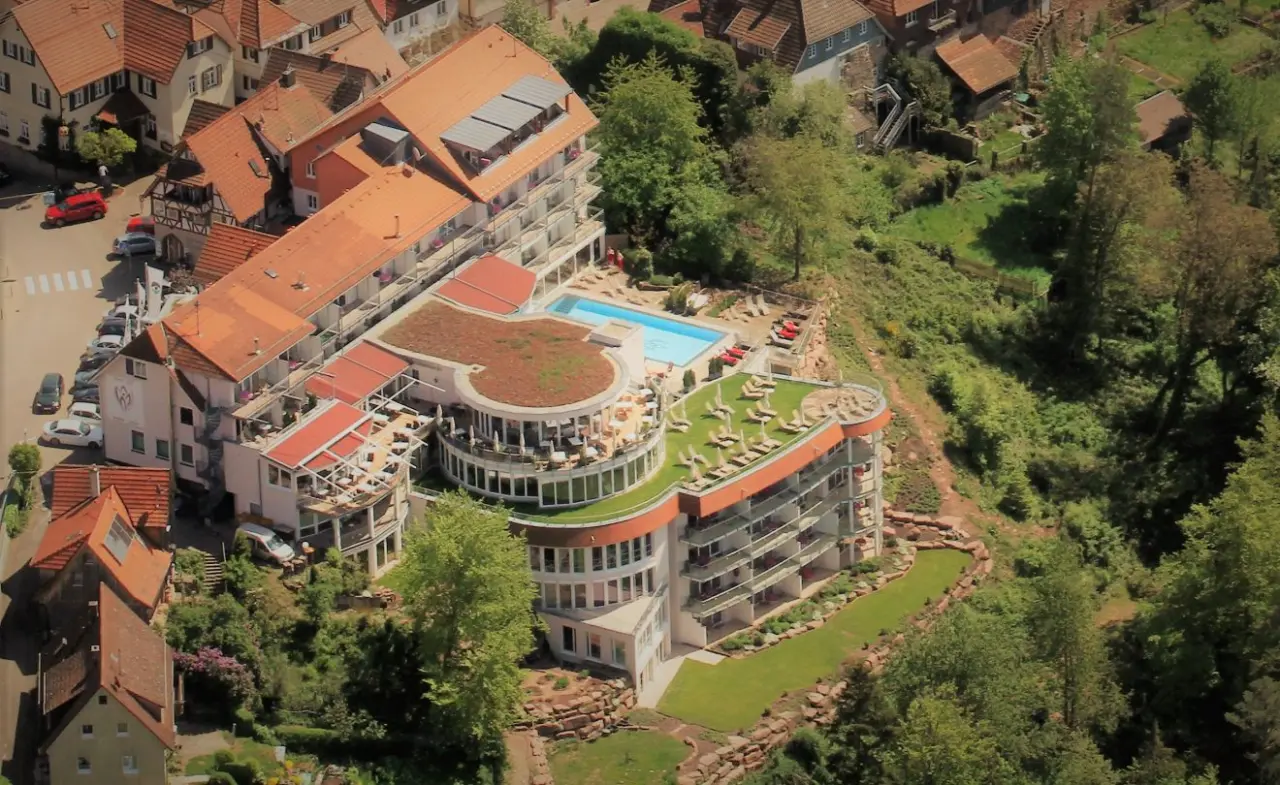 Luftaufnahme des Wellnesshotels Berlins KroneLamm mit Aussenpool, Sonnenterrassen und grünen Dächern, umgeben von Natur.