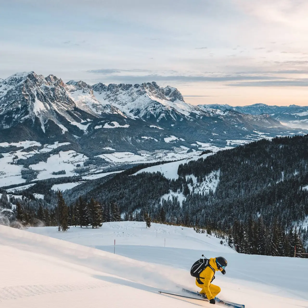 Skifahrer auf einer frisch präparierten Piste mit majestätischem Bergpanorama im Winter, nahe Hotel Kaiserhof.