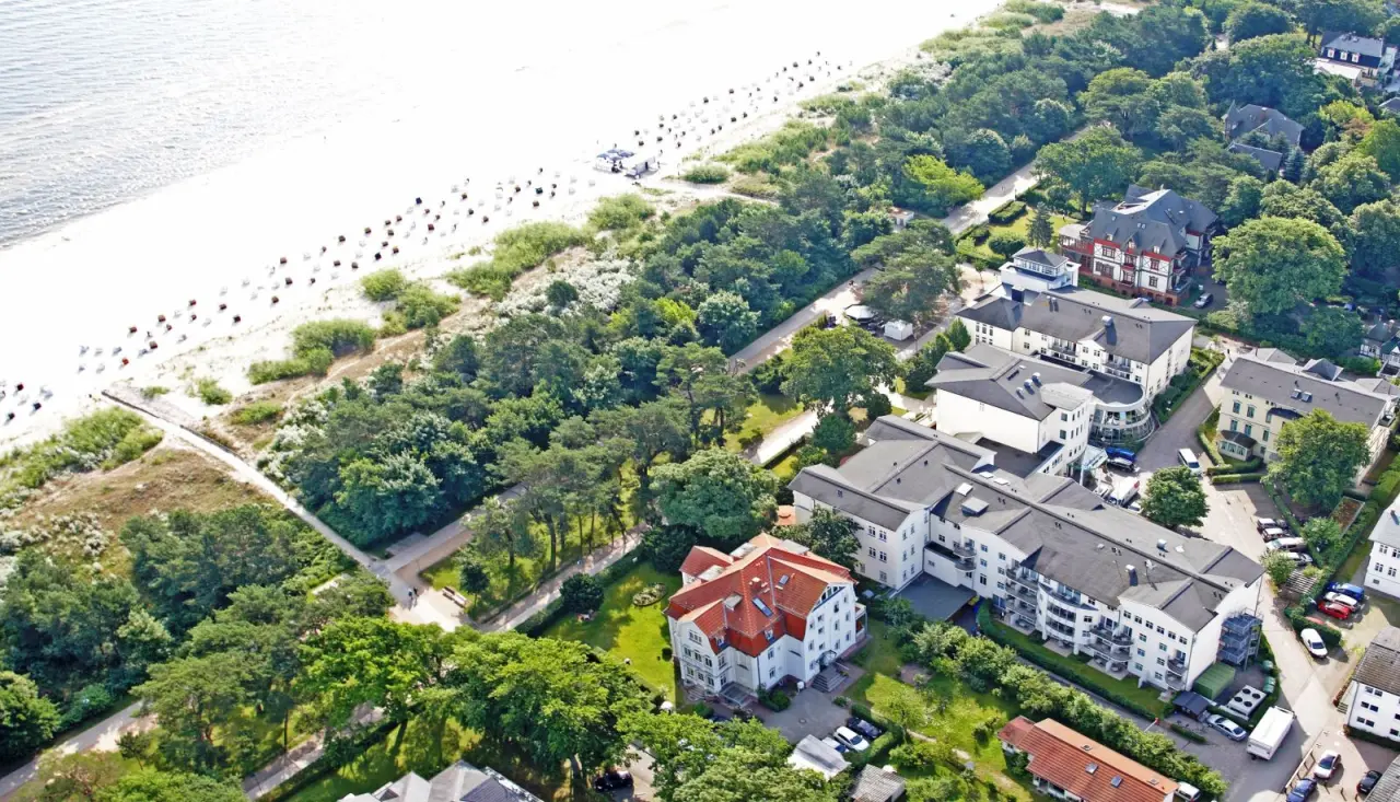 Luftaufnahme des Upstalsboom Hotel Heringsdorf direkt am breiten Sandstrand der Ostsee mit umliegender Natur.
