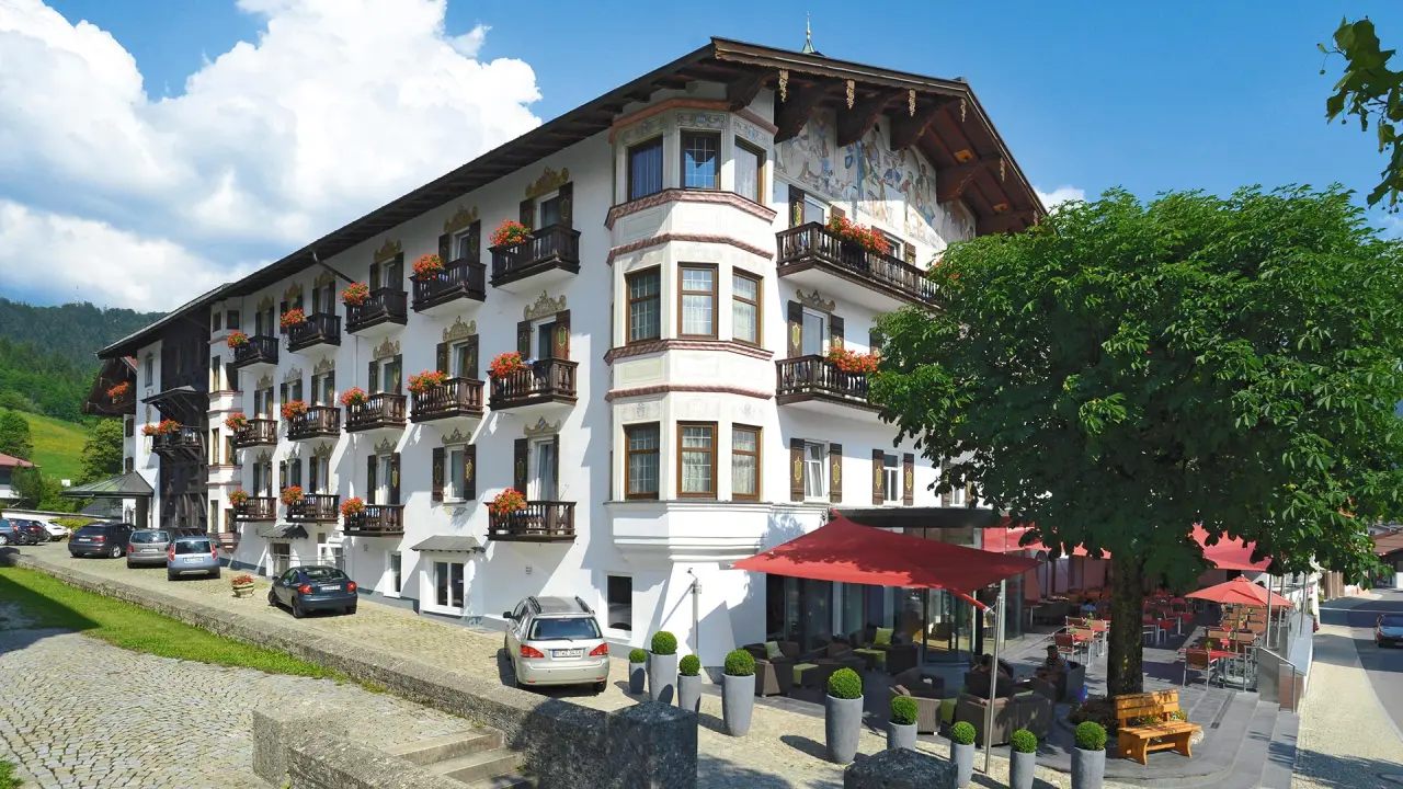 Traditionelles Hotel Unterwirt mit blühenden Balkonen und Aussenbereich in malerischer Alpenlandschaft.