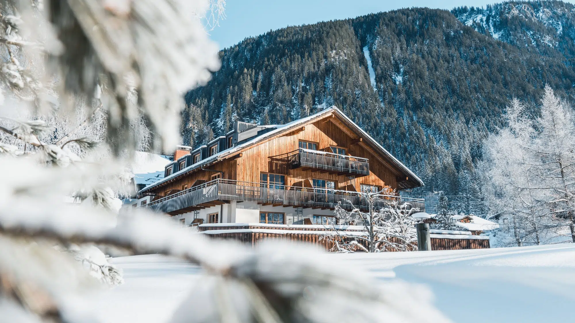 Hotel Felbermayer in Gaschurn – Winteransicht des Hotels mit verschneiter Berglandschaft | Wellnesshotel Montafon