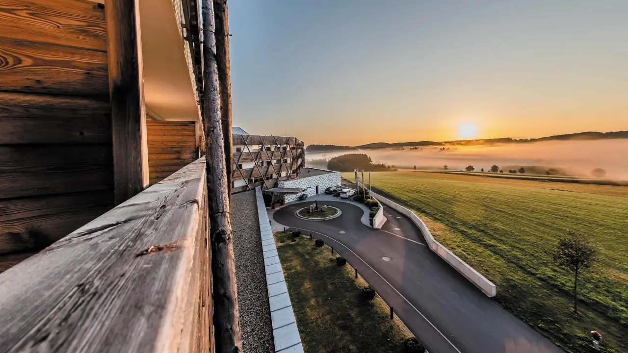 Malerischer Sonnenaufgang über dem nebelverhangenen Mühlviertel mit dem Falkensteiner Genuss & Wohlfühlhotel.