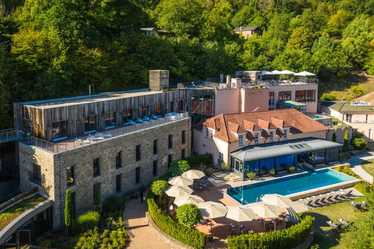 Luftaufnahme des BollAnts Spa im Park mit Hotelanlage, großem Außenpool und grüner Naturumgebung.