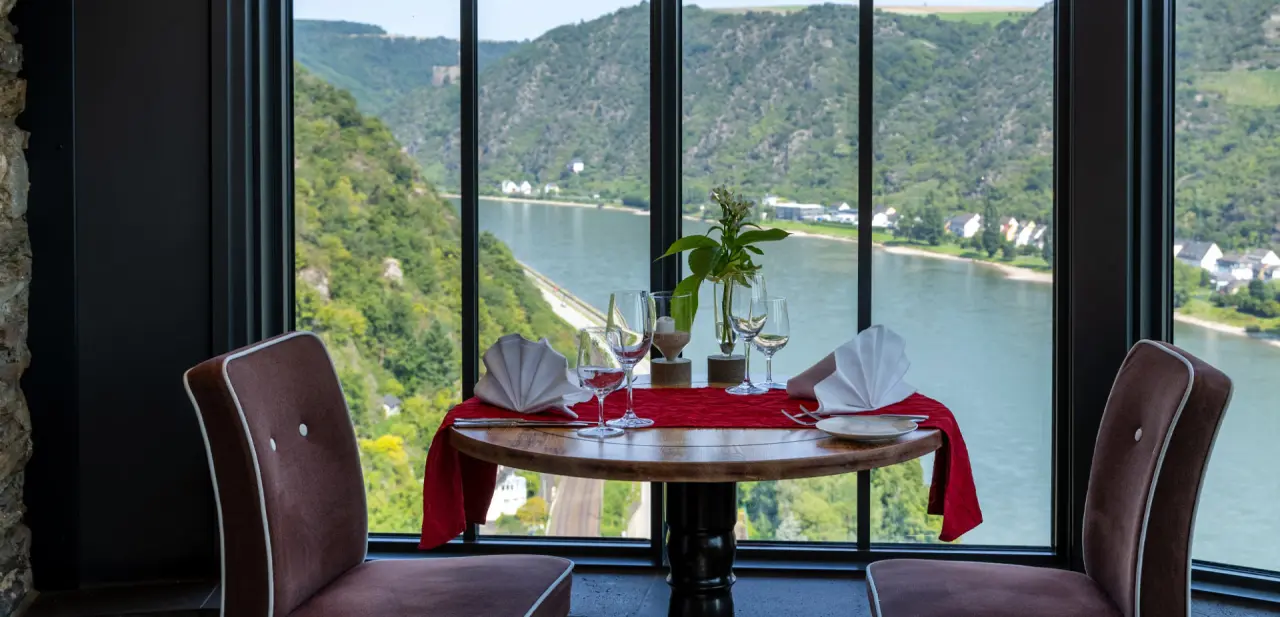 Romantisch gedeckter Tisch im Restaurant des Hotel Schloss Rheinfels mit Panoramablick auf den Rhein.