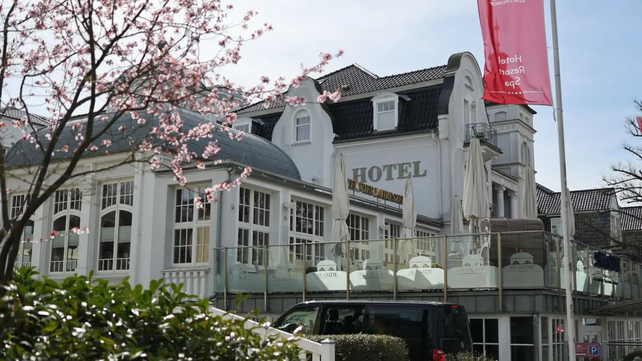 Aussenansicht des Hotel Vier Jahreszeiten Kühlungsborn mit blühenden Bäumen im Frühling.