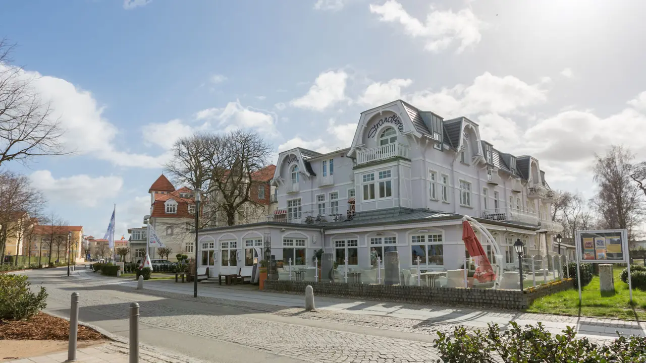 Historisches Hotel Vier Jahreszeiten Kühlungsborn an der Ostsee mit klassischer Bäderarchitektur und Außenterrasse.
