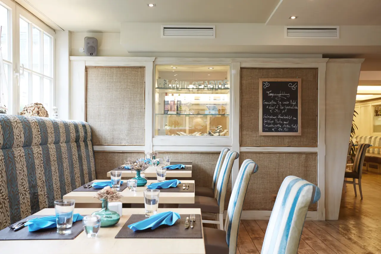 Gemütliches Restaurant im Hotel Vier Jahreszeiten Kühlungsborn mit maritimer Dekoration und Tagesempfehlung.
