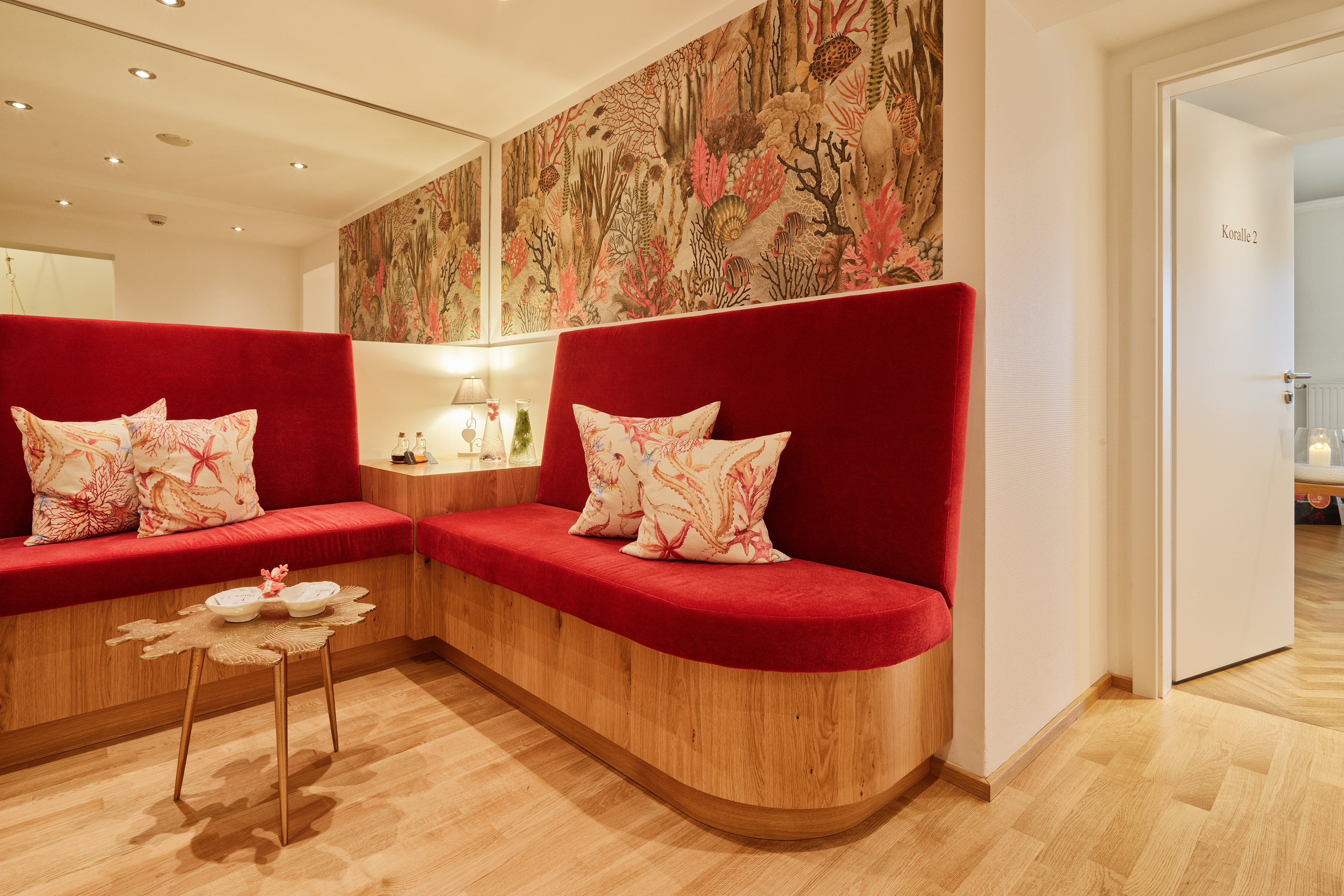 Hotel Villa Hügel in Trier – Stilvolle Sitzecke mit rotem Sofa und dekorativer Tapete | Wellnesshotel Mosel