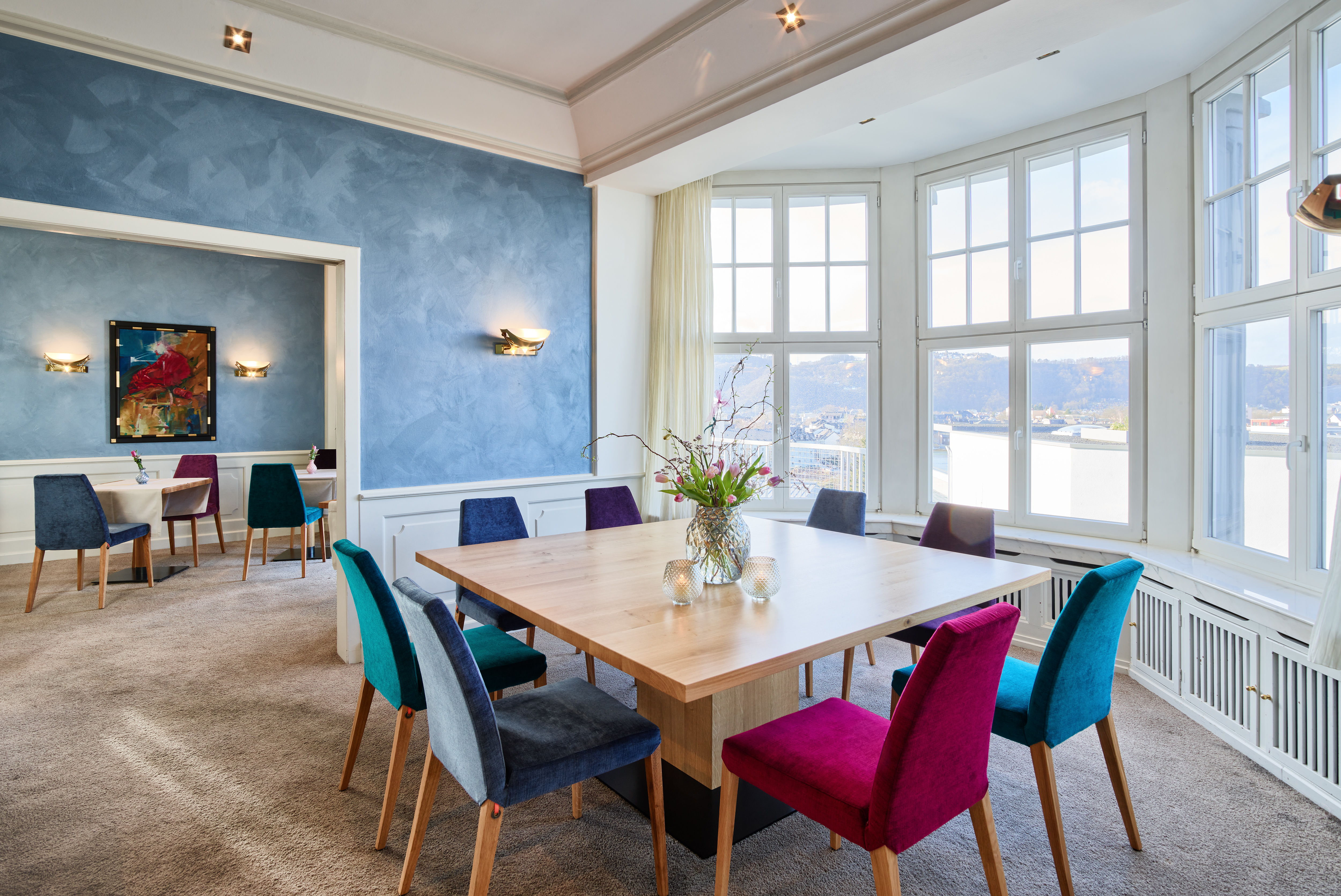 Hotel Villa Hügel in Trier – Heller Speisesaal mit bunten Stühlen und Ausblick | Wellnesshotel Mosel