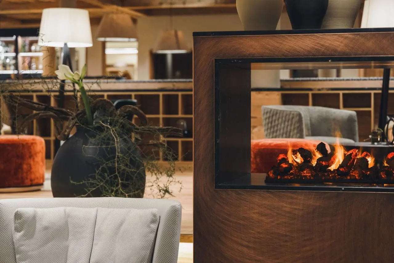 Alpenhotel Montafon in Schruns – Gemütliche Hotellobby mit modernem Kamin | Wellnesshotel Montafon