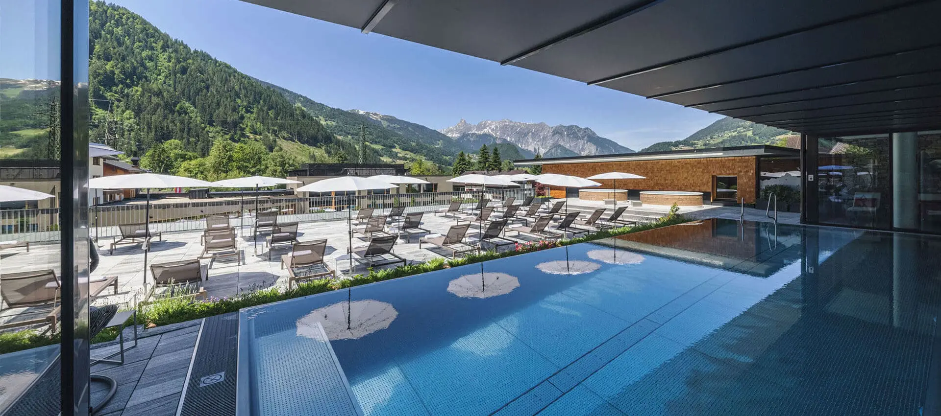 Alpenhotel Montafon in Schruns – Außenpool mit Liegen und Bergblick | Wellnesshotel Montafon