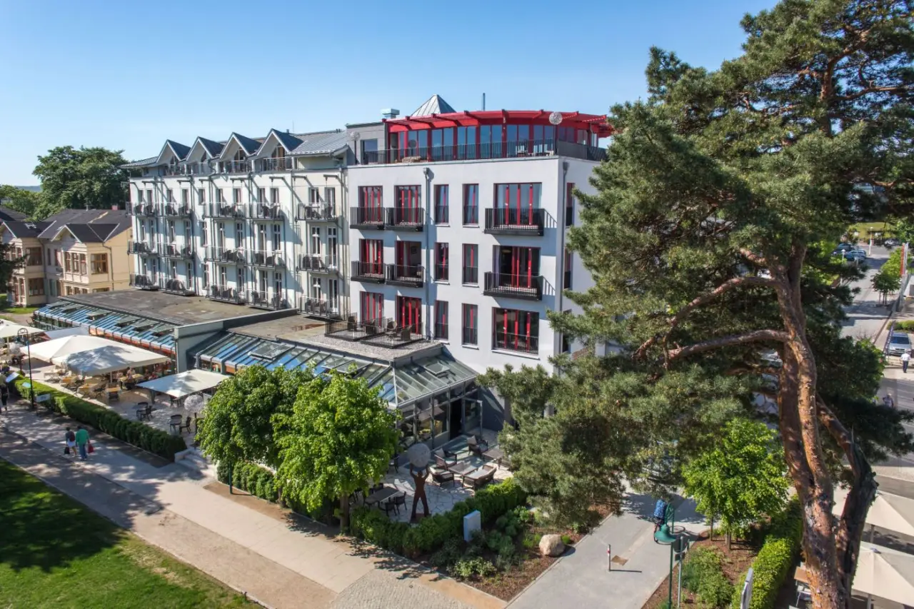 Aussenansicht des Strandhotel Heringsdorf mit moderner Architektur, Balkonen und Aussenbereichen unter blauem Himmel.