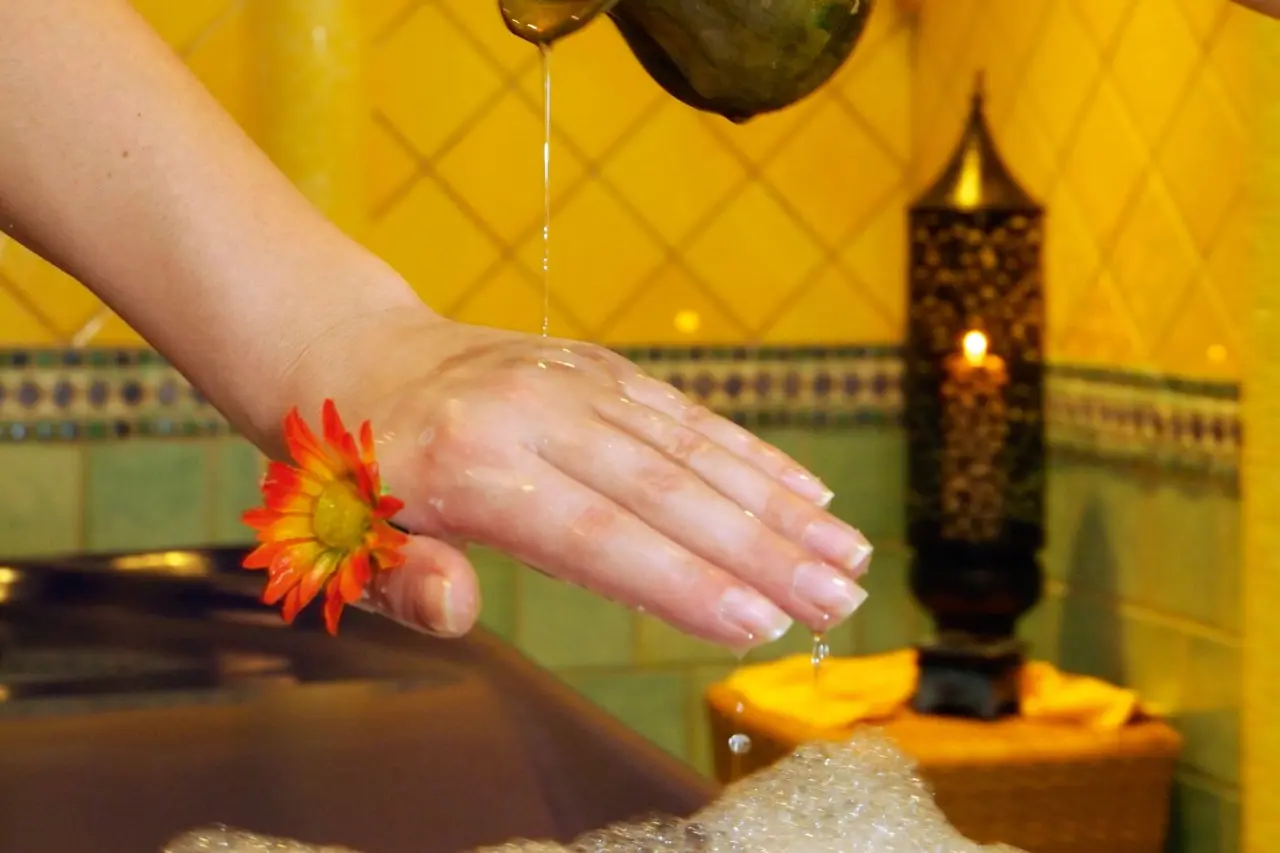 Öl-Anwendung auf einer Hand mit Blume während einer entspannenden Spa-Behandlung im Strandhotel Heringsdorf.
