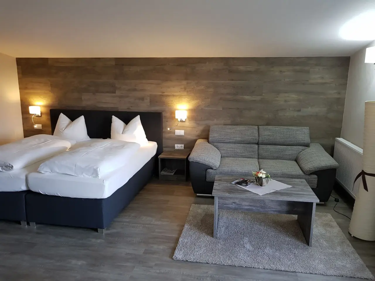 Gemütliches Doppelzimmer mit Boxspringbett und Sitzbereich im Hotel Spreewaldhof Romantik.