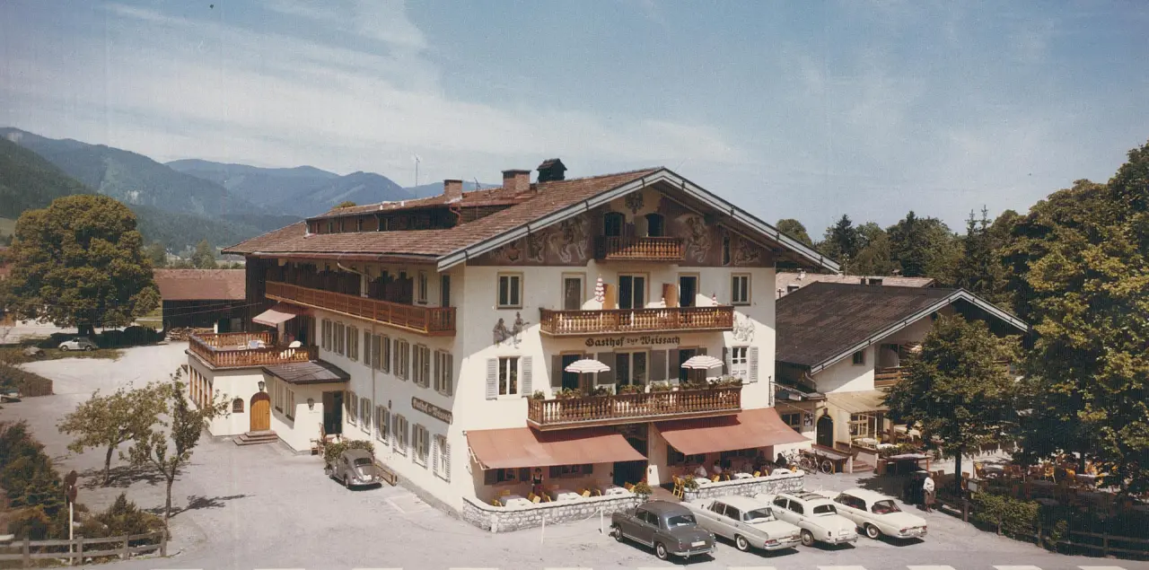 Historische Aussenansicht des Gasthofs zur Weissach mit traditioneller Architektur und alten Autos. Bachmair Weissach Spa & Resort.