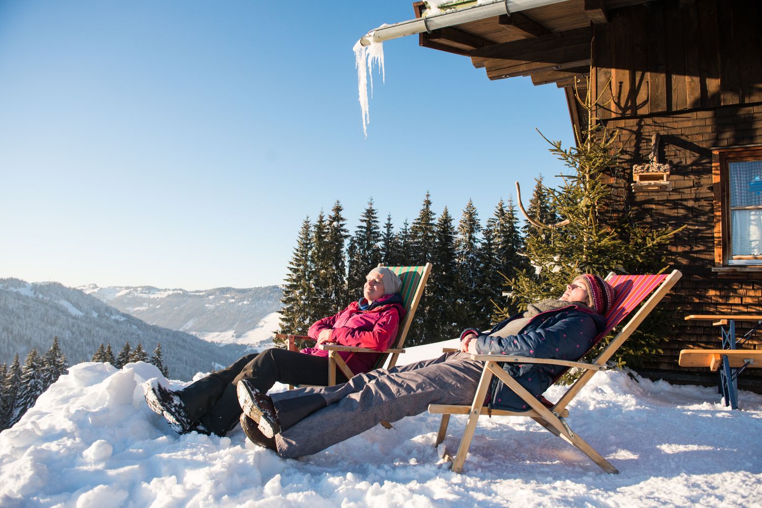 Hotel Rosenstock in Fischen im Allgäu – Gäste entspannen in Liegestühlen im Schnee | Wellnesshotel Allgäu