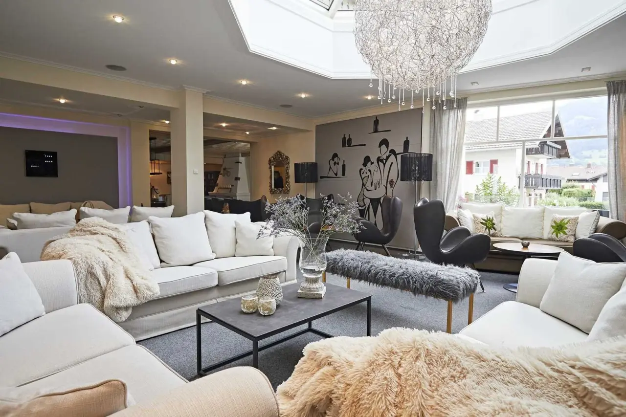 Einladende und moderne Hotellobby im Hotel Rosenstock mit bequemen Sofas, Design-Kronleuchter und Bergblick.