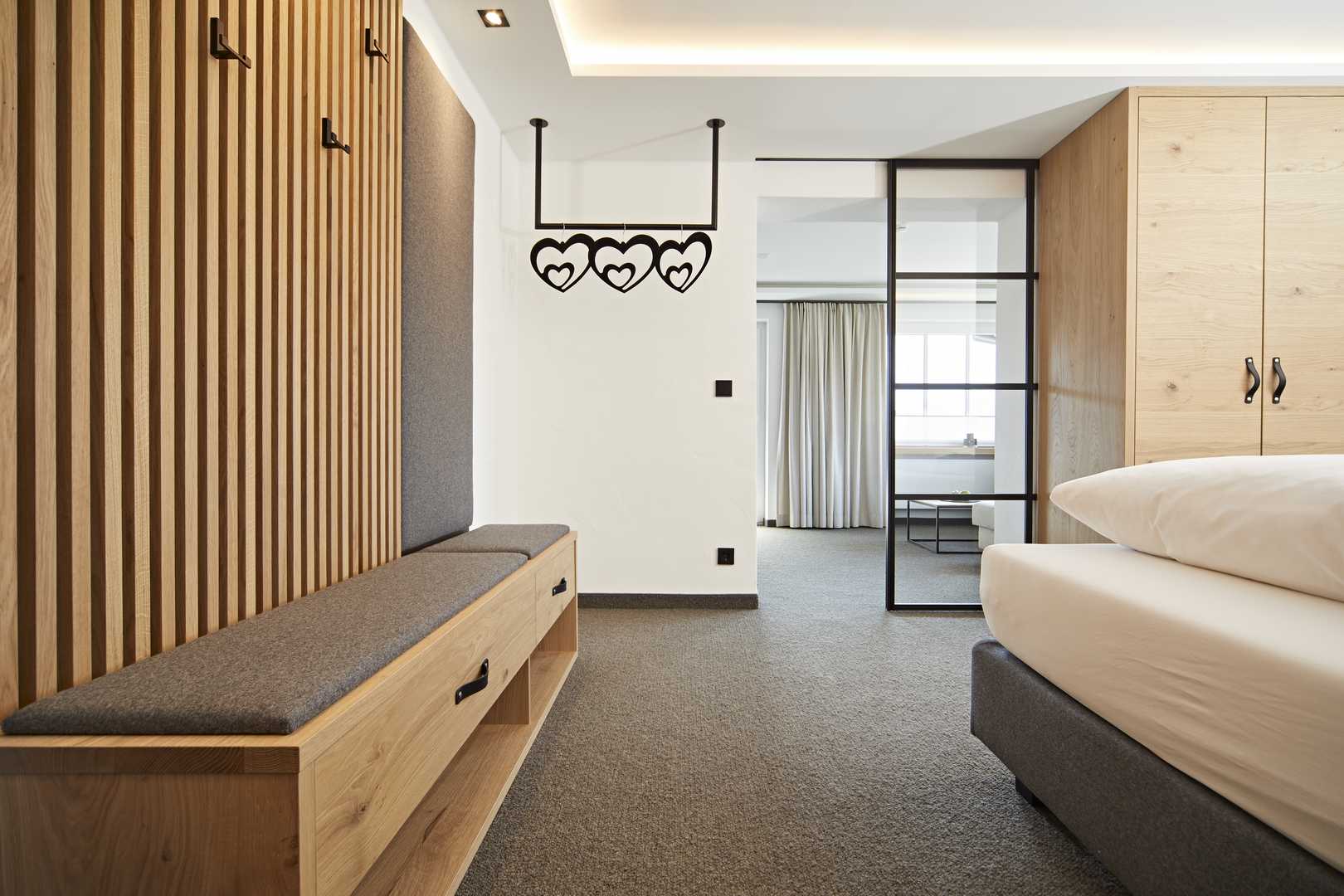 Hotel Rosenstock in Fischen im Allgäu – Modernes Hotelzimmer mit Holzelementen und Garderobe | Wellnesshotel Allgäu