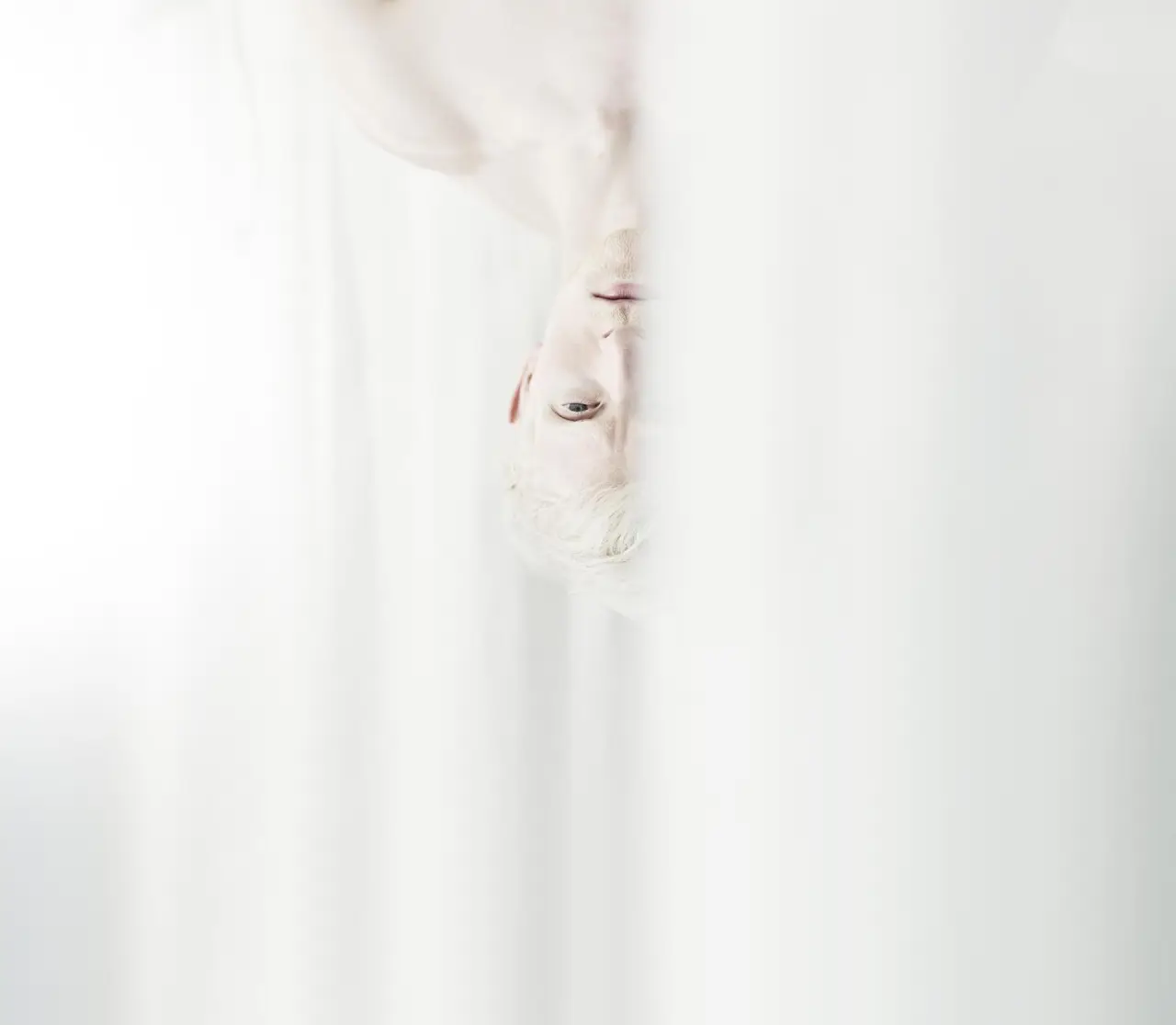 Abstraktes Porträt eines Mannes mit hellem Haar, teilweise verdeckt von weissem Stoff, im Wellnesshotel Engel.