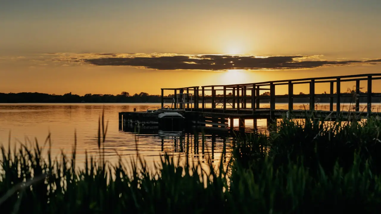 Idyllischer Sonnenuntergang am See mit Steg des Romantik Hotel Jagdhaus Eiden.