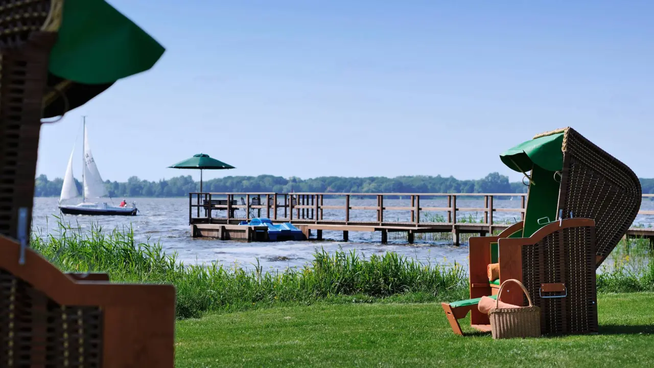 Strandkorb und Steg am Zwischenahner Meer mit Segelboot im Romantik Hotel Jagdhaus Eiden.