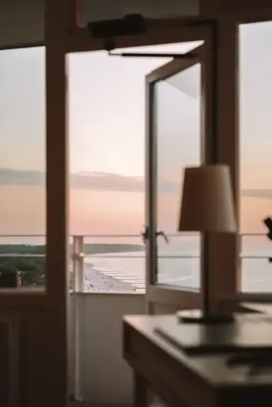 Blick vom Hotelzimmer des Hotel Neptun auf den Strand und die Ostsee bei Sonnenuntergang.