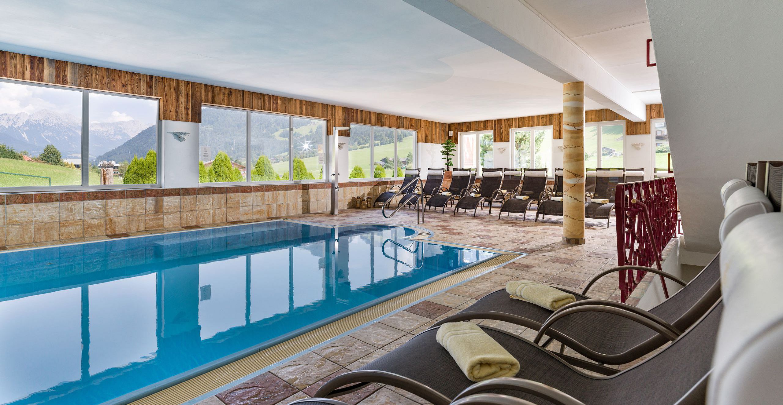 Sporthotel Tirolerhof in Itter – Innenpool mit Liegen und Bergblick | Wellnesshotel Tirol