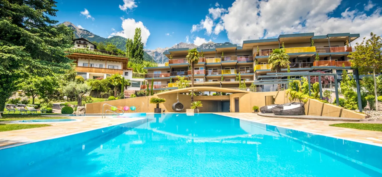 Feel Good Resort Johannis in Dorf Tirol – Außenpool mit Hotelansicht und Bergpanorama | Wellnesshotel Südtirol