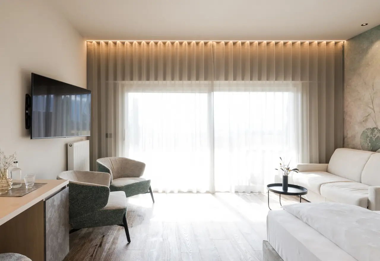 Feel Good Resort Johannis in Dorf Tirol – Modernes Hotelzimmer mit Sitzecke und hellem Ambiente | Wellnesshotel Südtirol