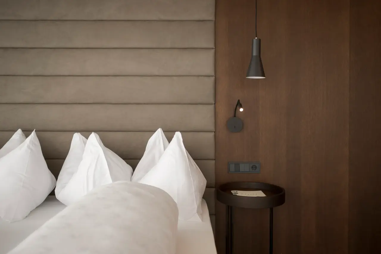 Feel Good Resort Johannis in Dorf Tirol – Modernes Hotelbett mit Holzpaneel | Wellnesshotel Südtirol