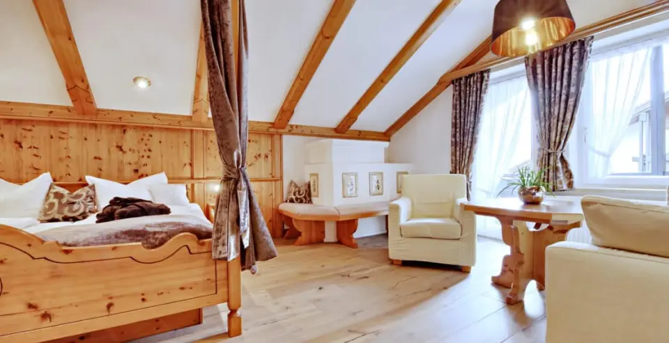 Gemütliches Doppelzimmer im alpenländischen Stil mit Holzbalken und Kachelofen im DIANA Naturpark Hotel.