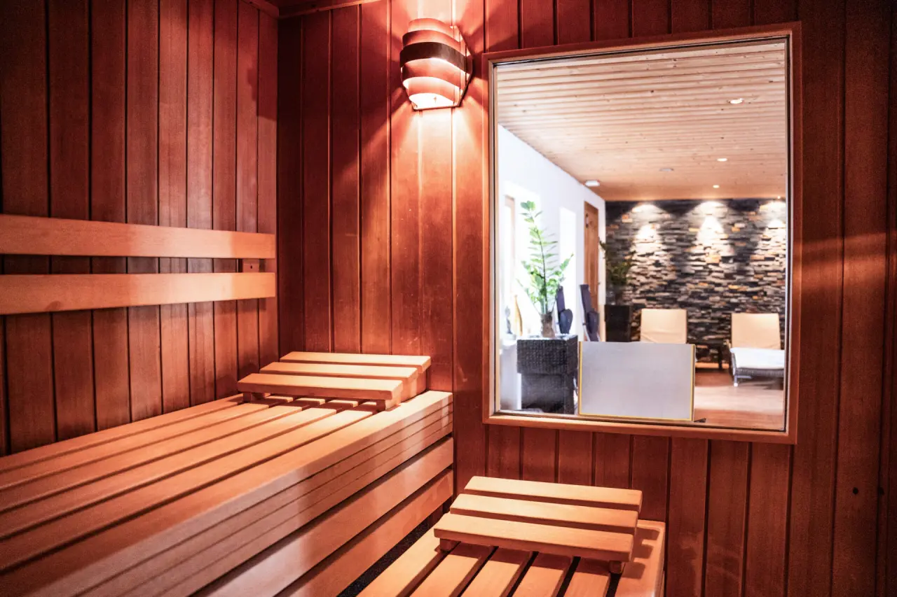 Moderne Holzsauna mit Blick auf den Ruheraum im DIANA Naturpark Hotel. Entspannung pur im Wellnessbereich.