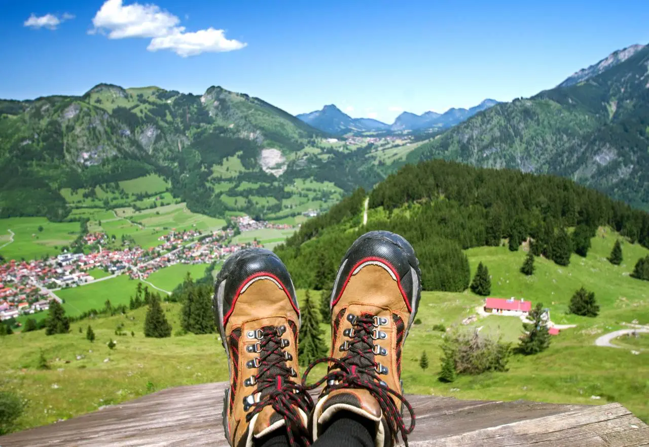 Hartung’s Hoteldorf in Füssen – Wanderstiefel vor malerischem Bergpanorama | Wellnesshotel Allgäu
