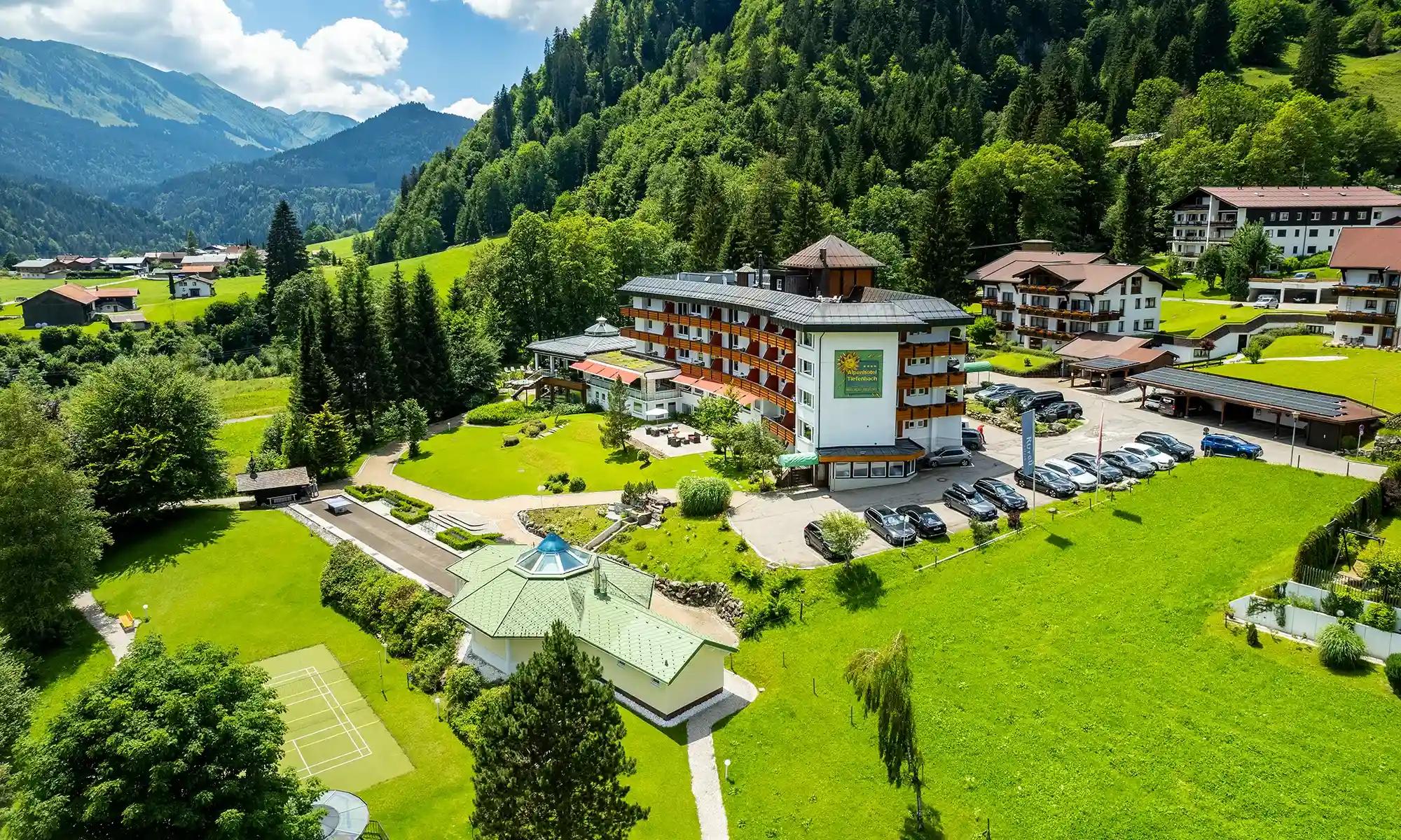Alpenhotel Oberstdorf in Oberstdorf – Luftaufnahme des Hotels mit grüner Berglandschaft | Wellnesshotel Allgäu