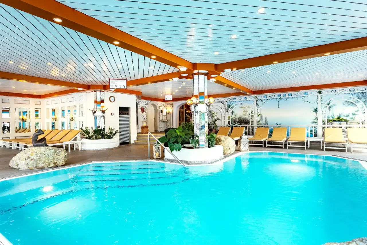 Alpenhotel Oberstdorf in Oberstdorf – Geräumiger Indoor-Poolbereich mit Liegen und Dekoration | Wellnesshotel Allgäu