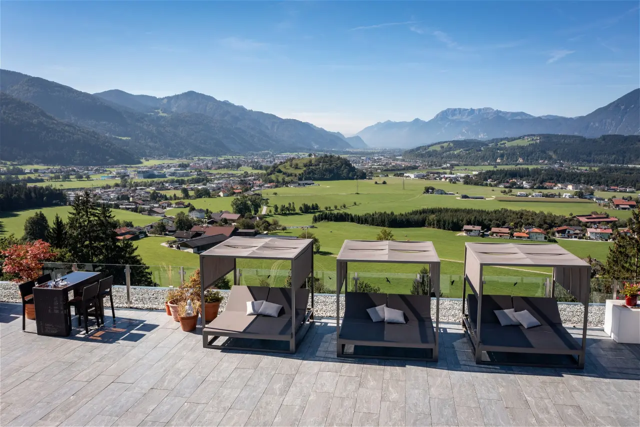 Sonnenterrasse mit luxuriösen Daybeds und atemberaubendem Bergpanorama im Hotel Panorama Royal.