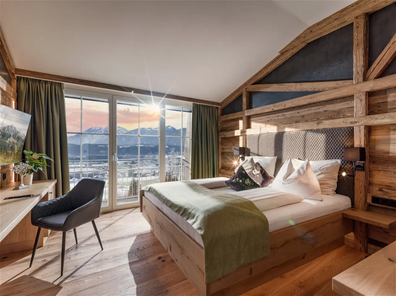 Alpines Doppelzimmer im Hotel Panorama Royal mit Holzbalken, gemütlichem Bett und Panoramablick auf die winterliche Bergwelt.