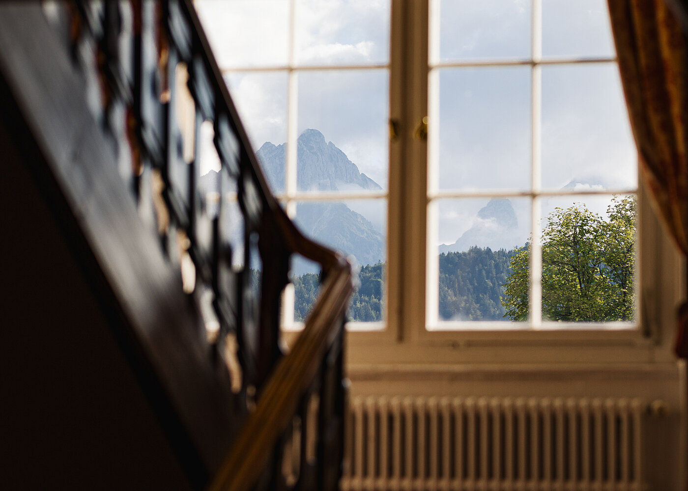 AMERON Neuschwanstein Alpsee Resort & Spa in Hohenschwangau – Bergblick aus einem Hotelfenster mit historischer Treppe | Wellnesshotel Allgäu