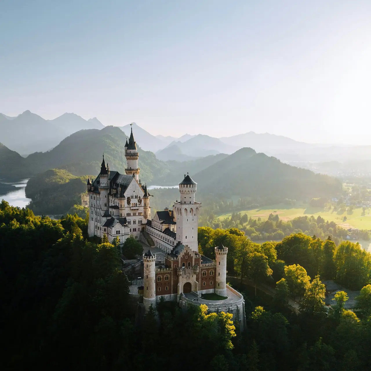 Schloss Neuschwanstein mit Alpenpanorama bei Sonnenaufgang, nahe AMERON Neuschwanstein Alpsee Resort & Spa.