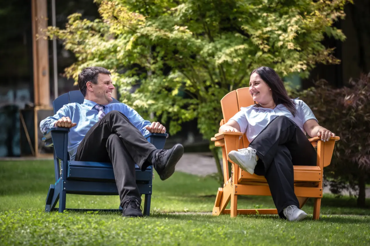 Gardenhotel Crystal in Fügen – Gäste entspannen in Adirondack-Stühlen im Hotelgarten | Wellnesshotel Zillertal