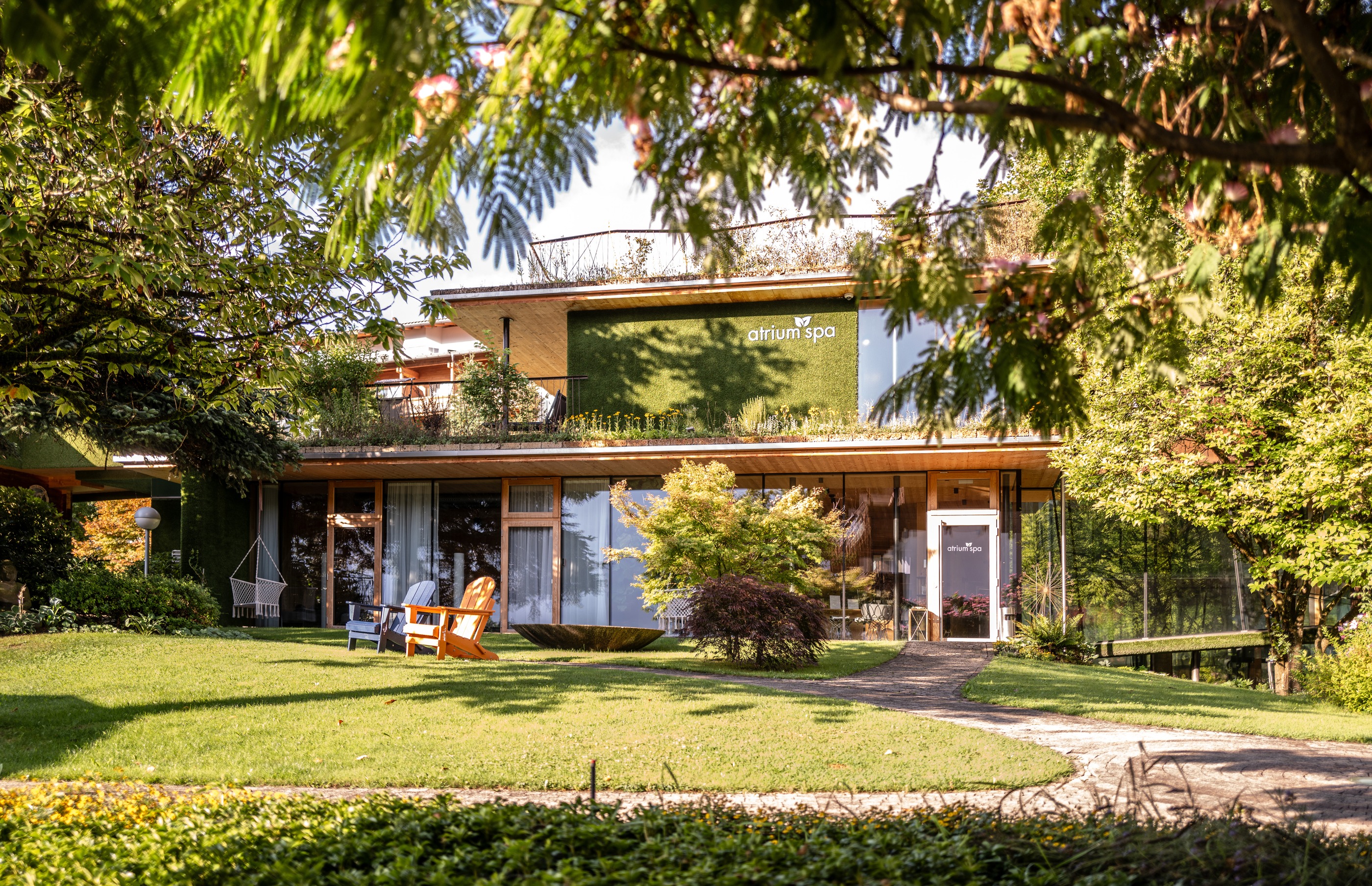Gardenhotel Crystal in Fügen – Modernes Atrium Spa Gebäude mit grüner Fassade und Gartenanlage | Wellnesshotel Zillertal