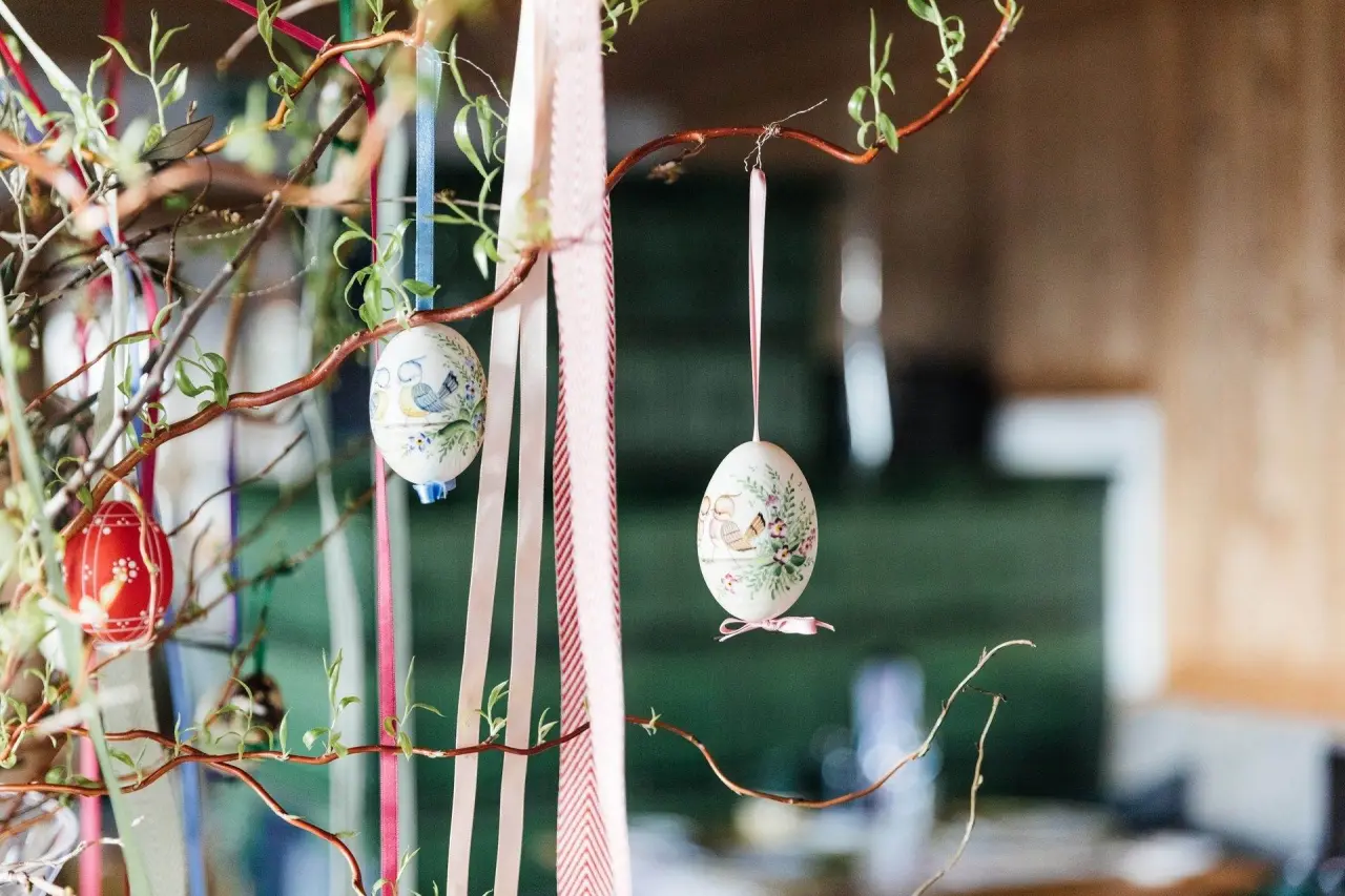 Osterdekoration mit bemalten Eiern und bunten Bändern an Zweigen im Juffing Hotel & Spa.