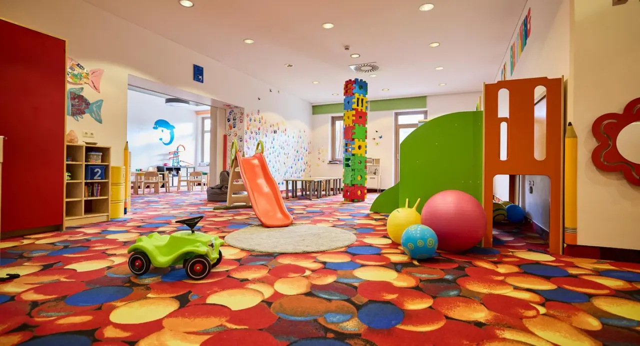 Farbenfroher Kinderclub mit Rutsche und Spielgeräten im Aldiana Club Ampflwang, ideal für Familien.