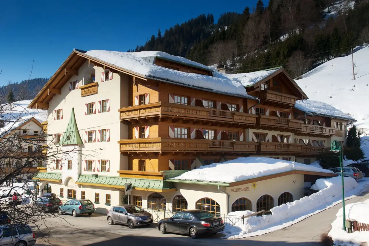 Aussenansicht des Wellnesshotel Mitterwirt im Winter mit verschneiten Dächern und Bergkulisse.