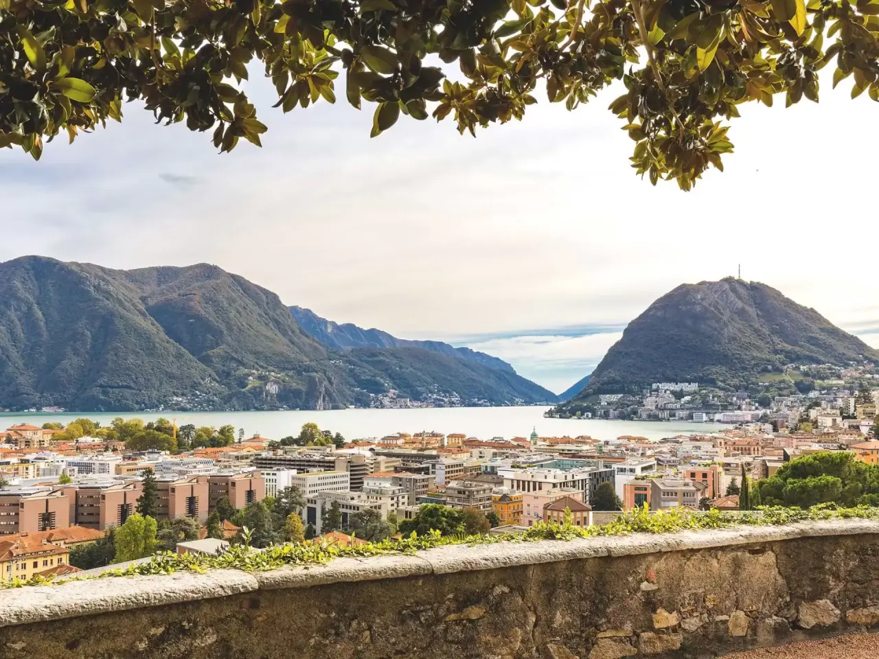 Panoramablick auf den Luganersee, die Stadt Lugano und die umliegenden Berge vom Villa Sassa Hotel Residence & SPA.