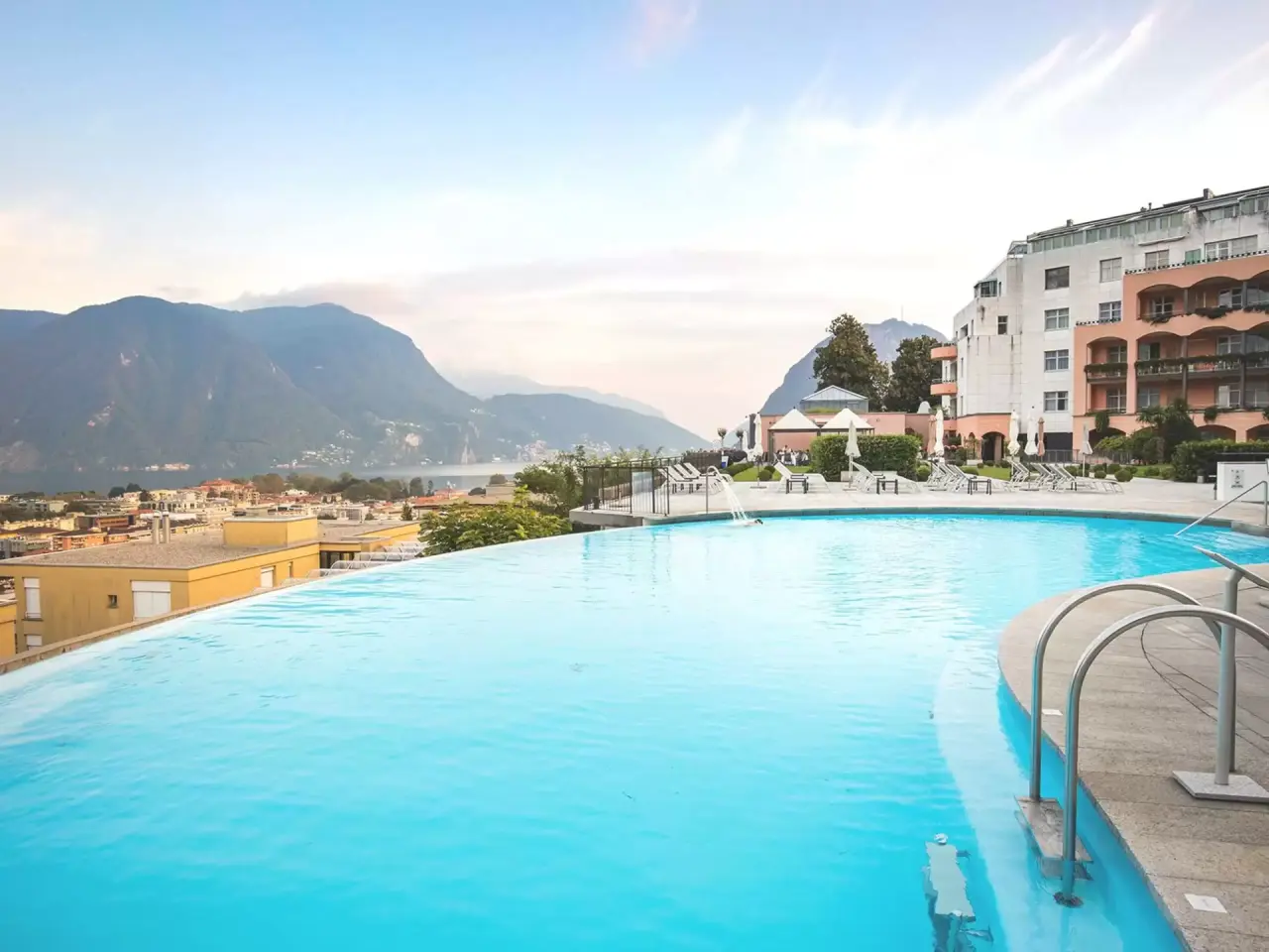 Infinity Pool mit Panoramablick auf den Luganersee und die Berge im Villa Sassa Hotel Residence & SPA.